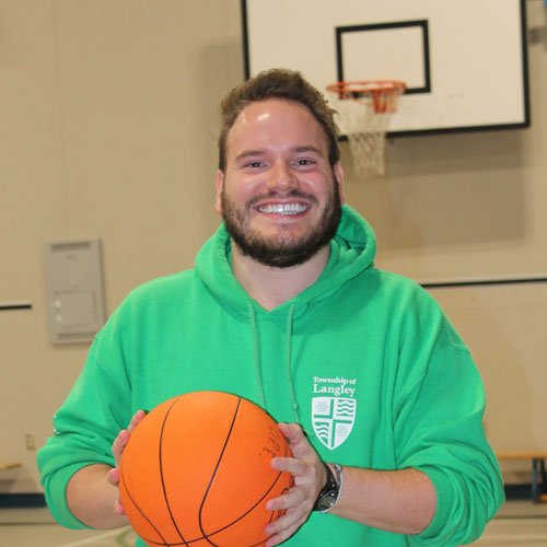 A recreation staff member holding a basketball.