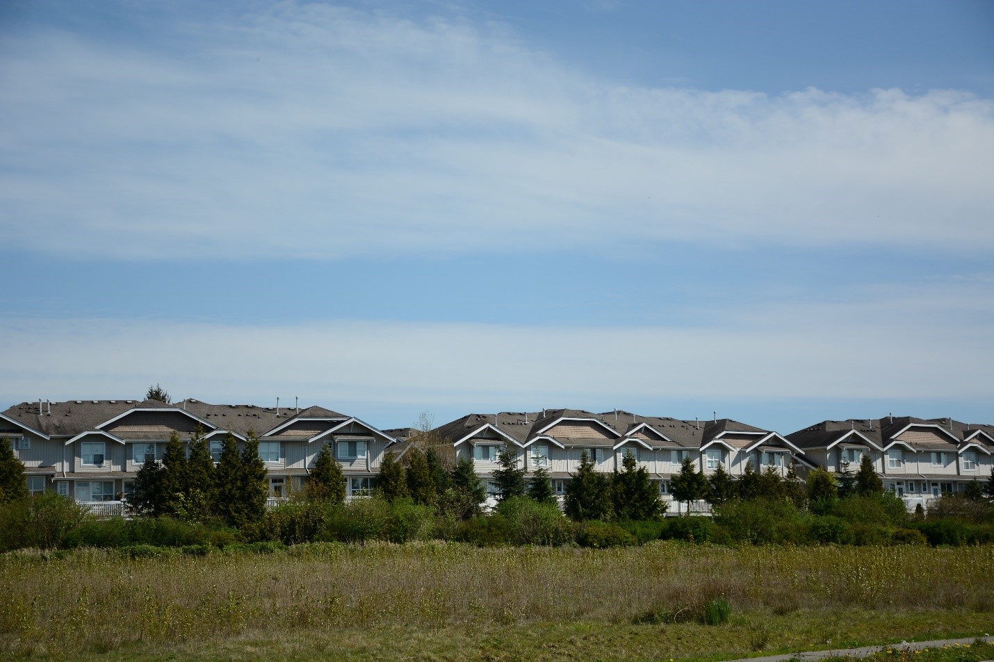 A wide shot of homes built on the edge of farmland.